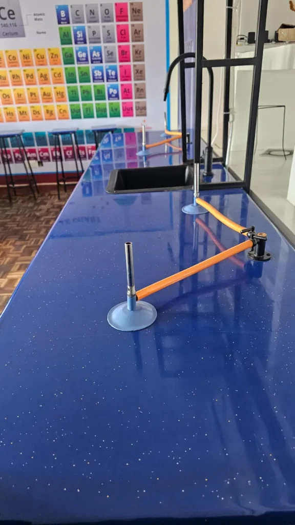 Science lab bench with a periodic table wall chart at Cares Home-based Tuition, Nairobi
