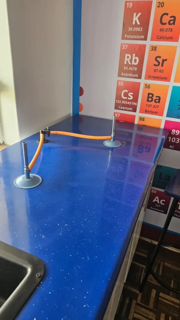 Chemistry lab with a periodic table wall chart and sink at Cares Home-based Tuition