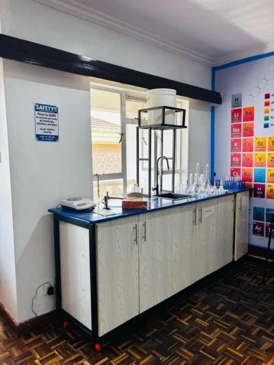 Bench marked Biology with an electronic balance, sink, glassware and a safety sign on the wall