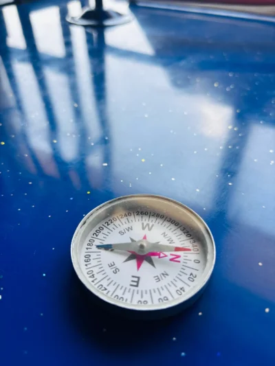 Magnetic compass with a degree scale lying on a blue bench