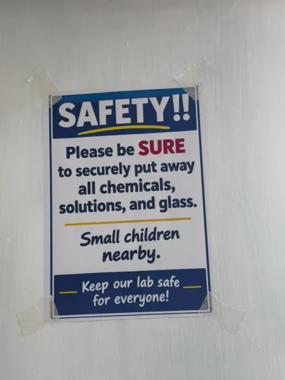 Wall sign that asks users to put away all chemicals, solutions and glass because small children are nearby